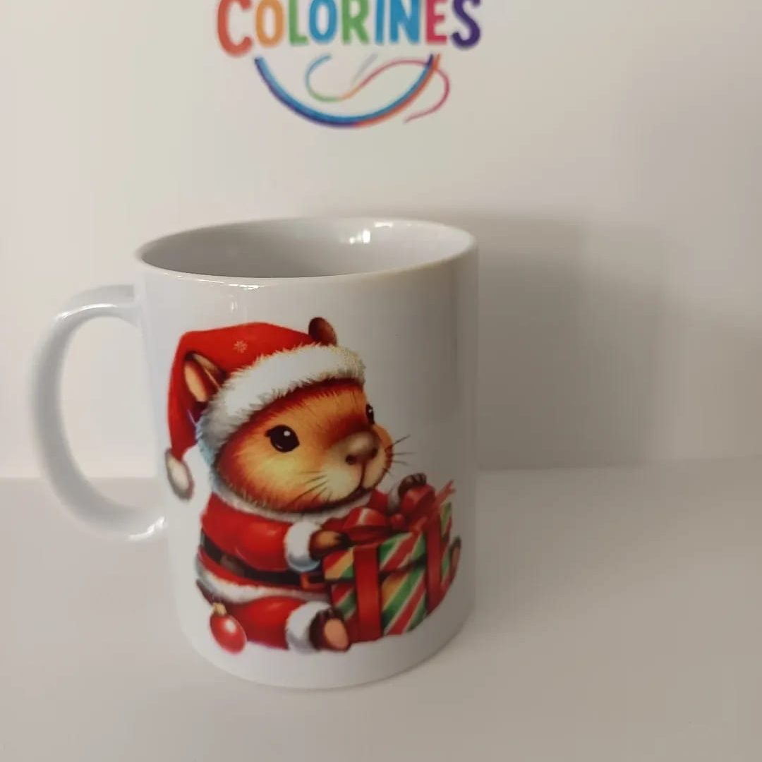 Taza con un capibara navideña sosteniendo un regalo, fondo blanco.