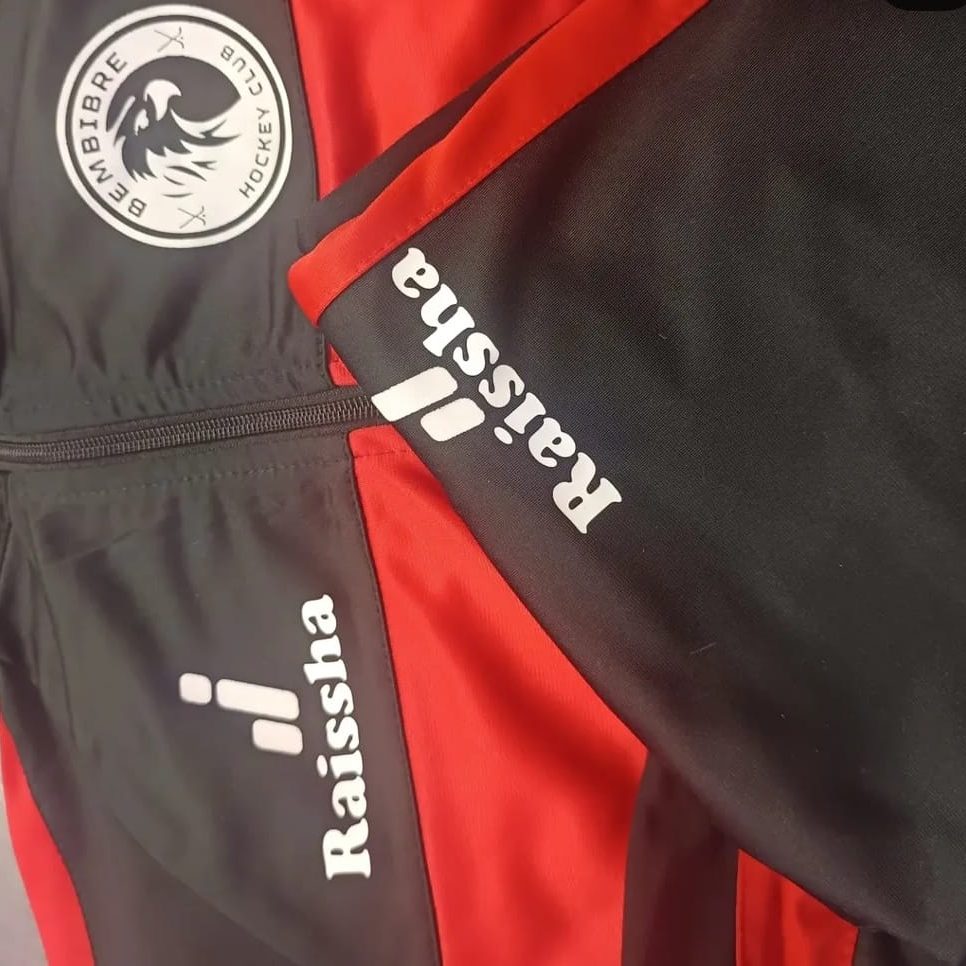 Parte de una prenda deportiva con logotipos personalizados  en colores negro y rojo.